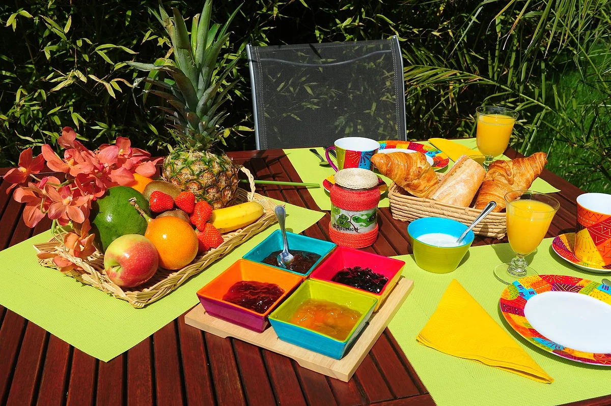 Le petit déjeuner servi avec fruits frais, confitures maison et vaisselle colorée
