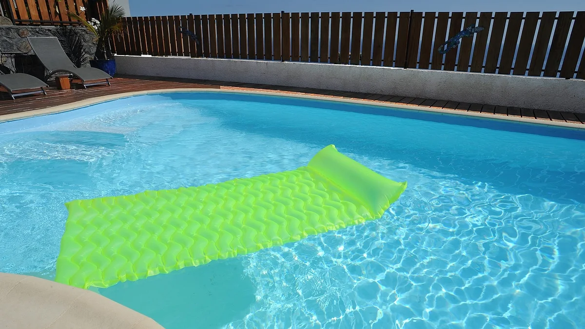 L'eau turquoise de la piscine et un matelas flottant