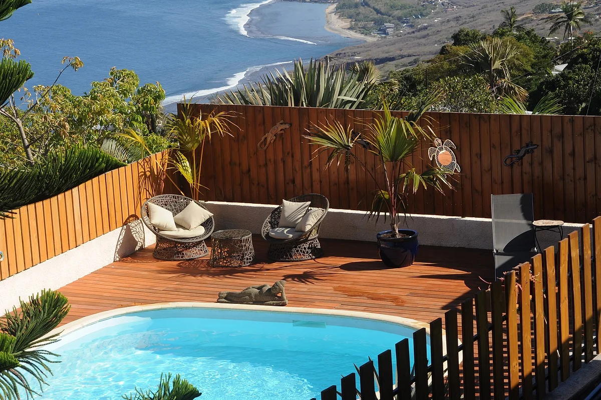 La piscine chauffée entourée de sa terrasse en bois et de transats