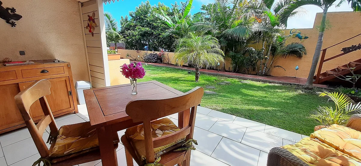 La table d'une terrasse avec la pelouse et les palmiers devant
